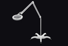 Load image into Gallery viewer, Omega 5 magnifying lamp with floorstand attached, against a black background.