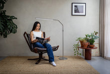 Load image into Gallery viewer, Young woman reading in an armchair using a floor lamps