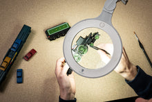 Load image into Gallery viewer, Image of magnifying lamp being used to paint a green miniature train.