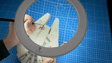 Load image into Gallery viewer, Omega 5 magnifying lamp being used to paint a miniature space craft in greys and white.