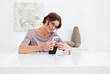 Load image into Gallery viewer, Woman using Mobilux LED with Mobase to thread a needle.