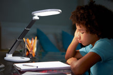 Load image into Gallery viewer, Young boy studying at a desk with Daylight's Foldi Go.
