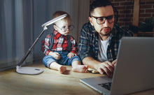 Load image into Gallery viewer, Father and toddler looking at a computer on a desk, with Daylight's Foldi Go.