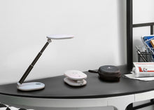 Load image into Gallery viewer, Daylight's Foldi Go, in extended form, compact form and in the case, all on a desk.