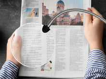 Load image into Gallery viewer, Daylight's magnifying arm , placed over a travel book