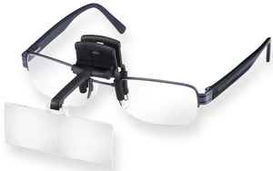 Magnifying lens on black carrier, clipped onto glasses.