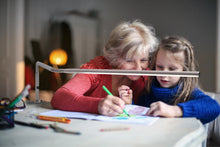 Load image into Gallery viewer, Woman and child drawing underneath the Slimline table lamp..
