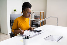 Load image into Gallery viewer, Girl studying at a desk with Daylight&#39;s Slimline table lamp
