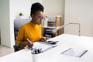 Girl studying at a desk with Daylight's Slimline table lamp