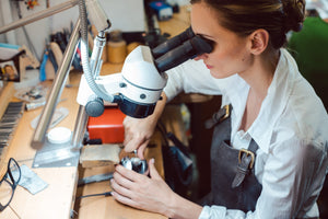 Jeweler using Slimline table lamp, along with a microscope.