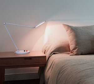 Daylight's Tricolour lamp on a bedside table.