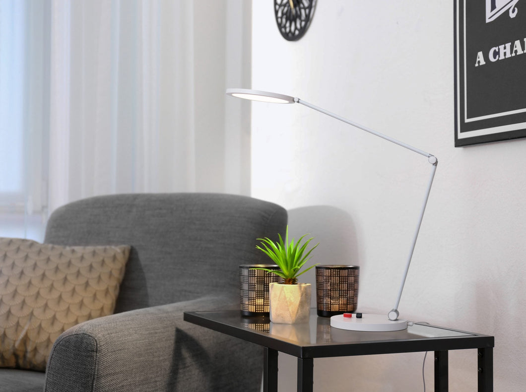 Daylight's Tricolour lamp on a small table next to a couch.