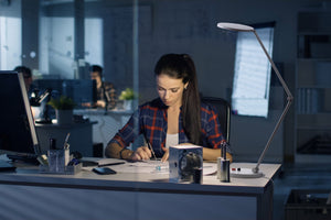 Woman using Daylight's Tricolour lamp in an office