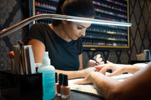 Load image into Gallery viewer, Daylight&#39;s Slimline Floor-standing lamp being used in a nail salon.
